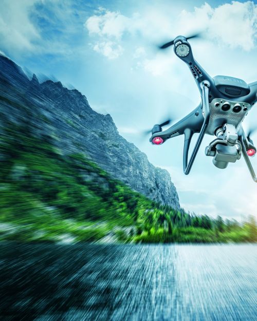Dark drone in the air against the backdrop of a mountain landscape.